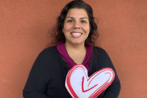 Volunteer Center Staff member holding the Volunteer Center Heart logo in her hand