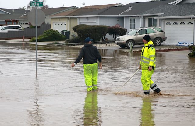 Emergency workers trek through flooded streets near Bay Village in Watsonville in January. —Tarmo Hannula/The Pajaronian